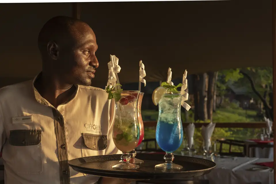 A barman presenting two cocktails